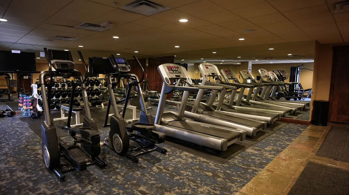 A bright, modern fitness center filled with treadmills, ellipticals, dumbbells, and large mirrors. The space feels energetic and well-equipped, ideal for maintaining fitness routines or challenging yourself during your stay.