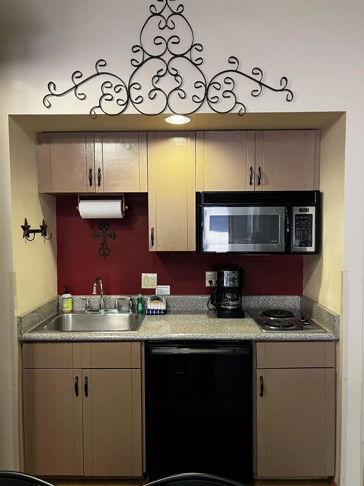 A modern kitchen with granite countertops, stainless appliances, and decorative ironwork above the cabinets. The space is designed for both functionality and gatherings, making it ideal for preparing meals or sharing brunch with friends before heading out to explore.